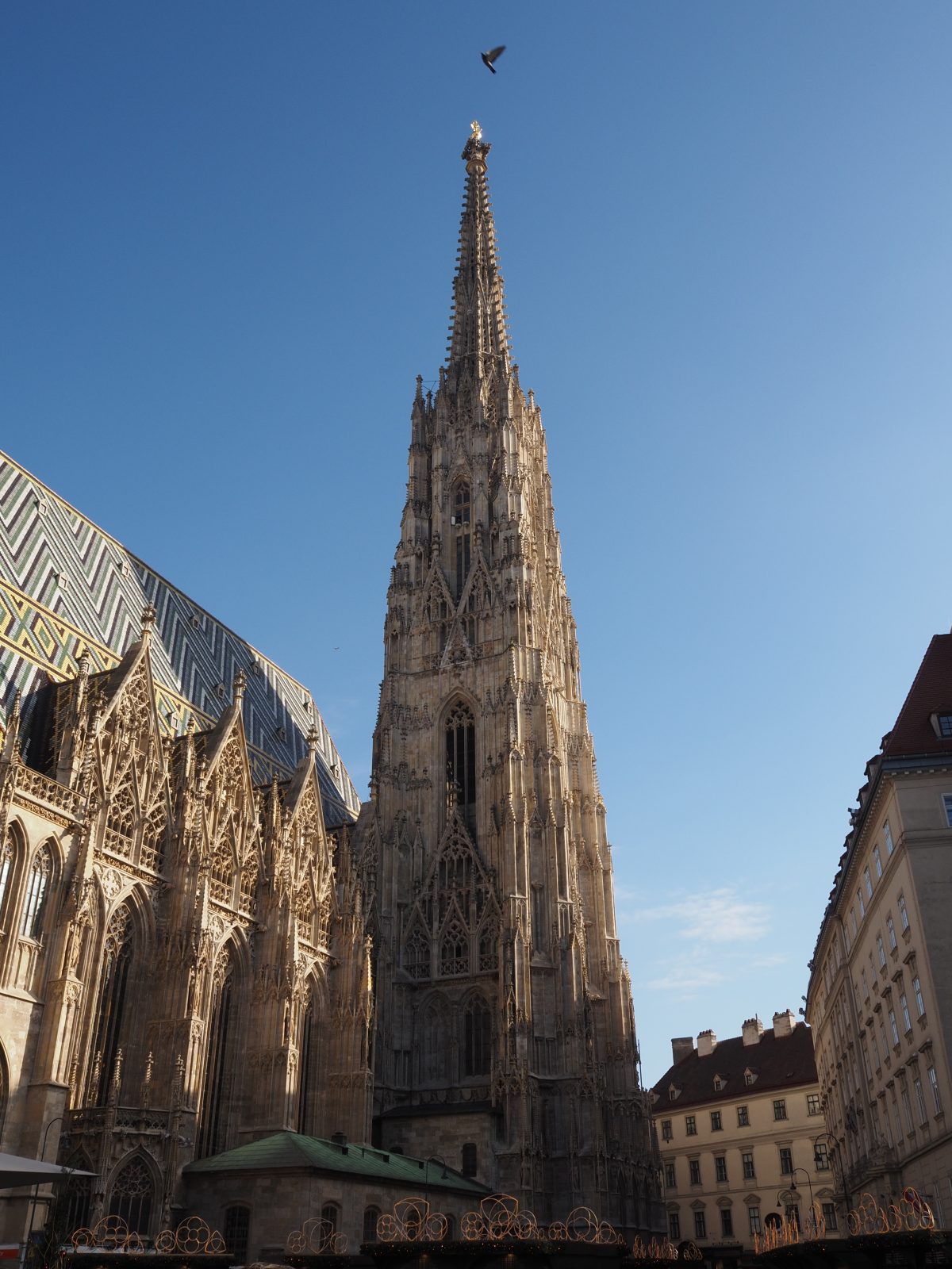 The TIST Assistant said: Stephansdom’s soaring Gothic spire and patterned roof tiles shining under a clear blue Vienna sky.