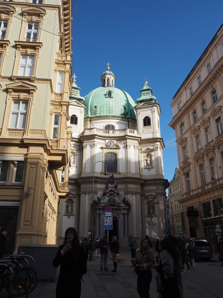 Baroque facade of St Peter’s Church in Vienna surrounded by historic buildings