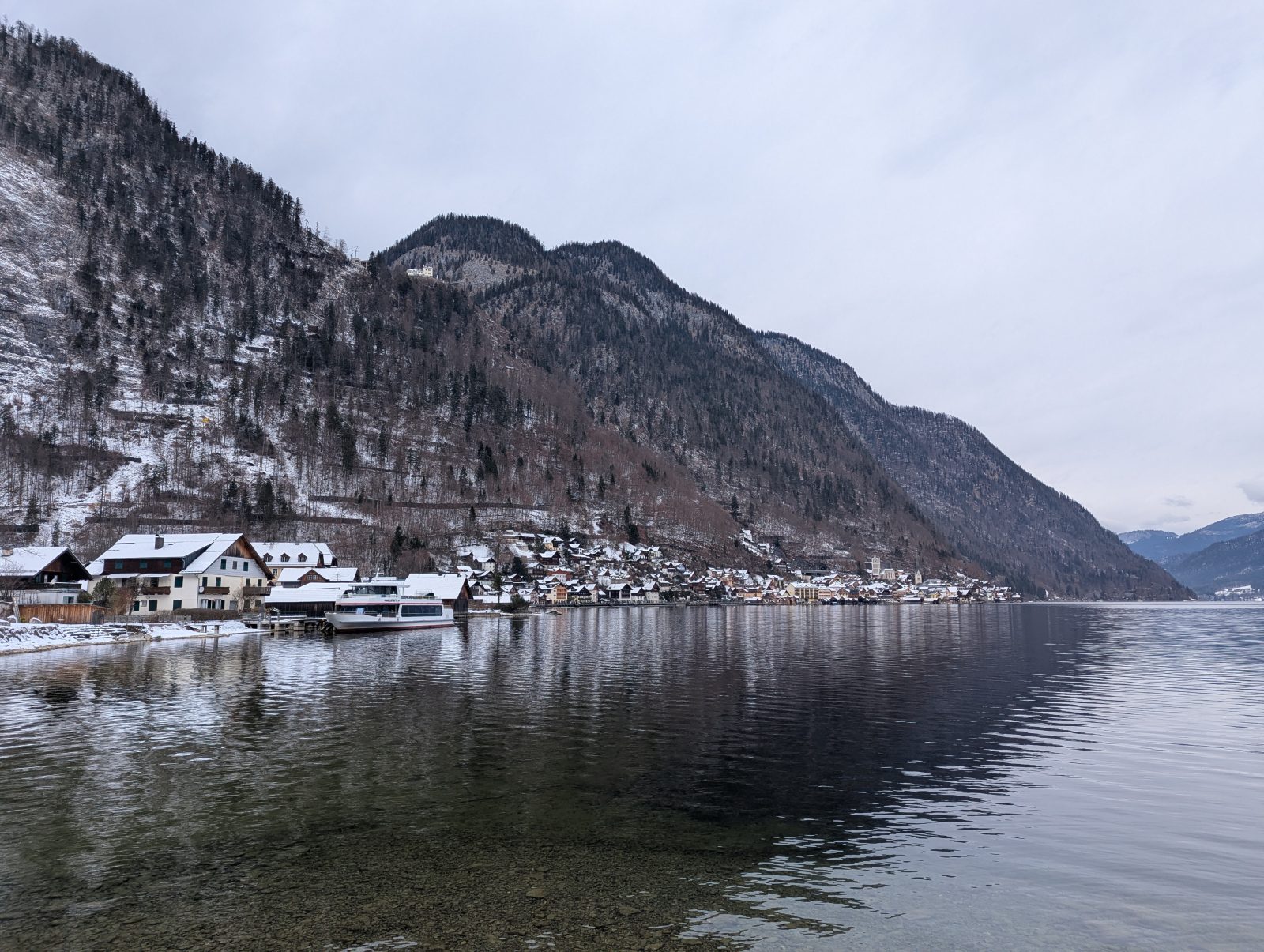 Winter view of Hallstatt village reflected in Lake Hallstatt with alpine mountains